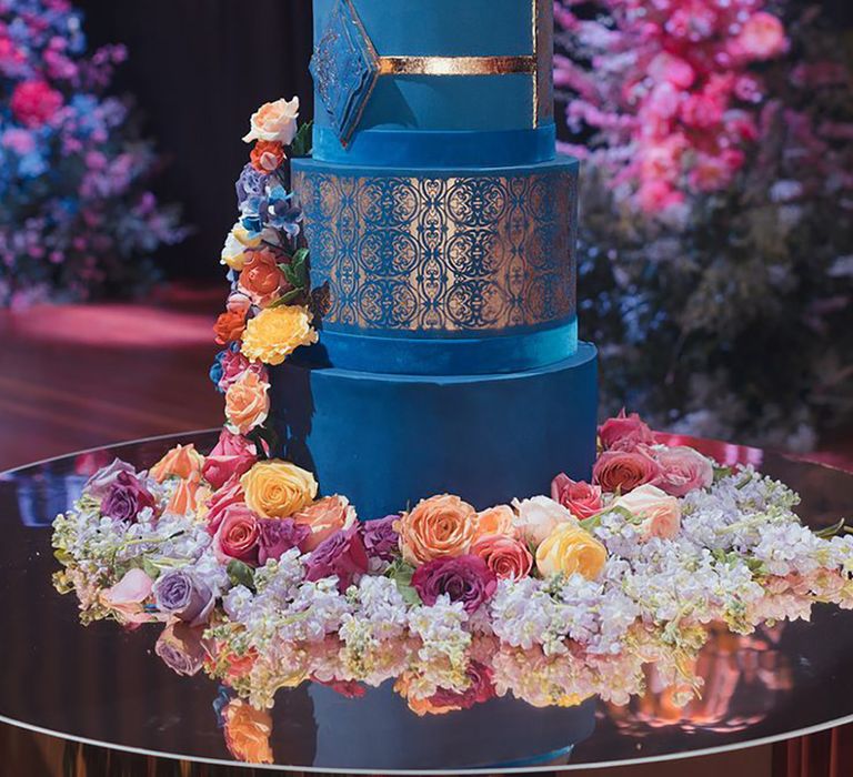 Luxury epic five tier navy blue wedding cake with gold detailing and colourful wedding flowers for African wedding 