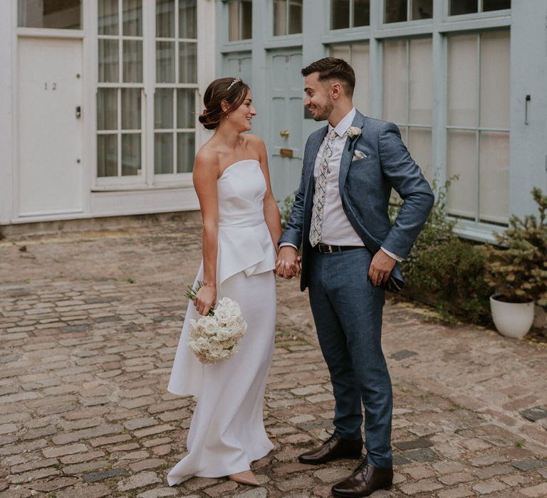 Bride in strapless Roland Mouret wedding dress and groom in blue suit