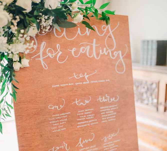 Wooden table plan sign with floral decor 