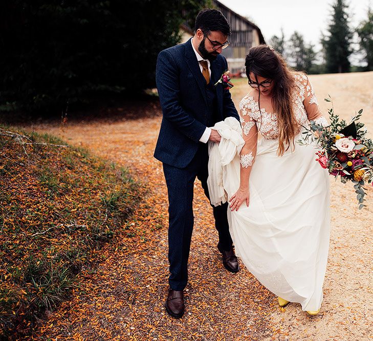 Bride clutches bouquet in bespoke wedding dress