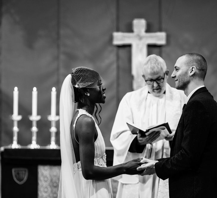 Bride and groom holding hands at the altar of their St Nicholas church wedding in Liverpool