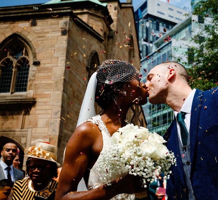 Bride and groom kissing outside St Nicholas Church in Liverpool