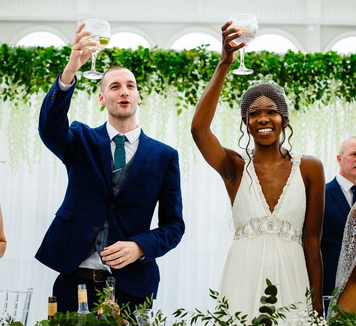 Bride and groom raising their glasses at the glasshouse wedding reception 