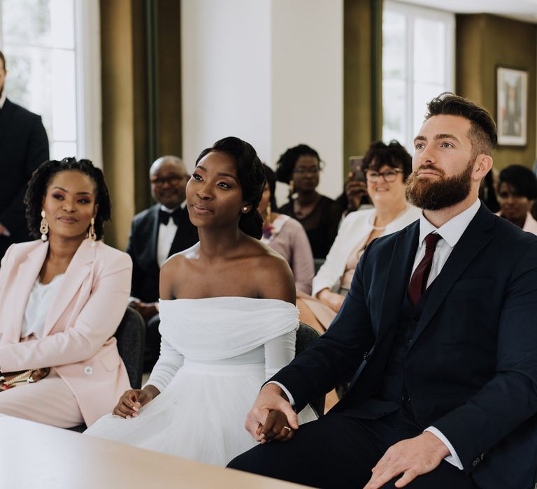 Bride and groom holding hands during the civil wedding ceremony 