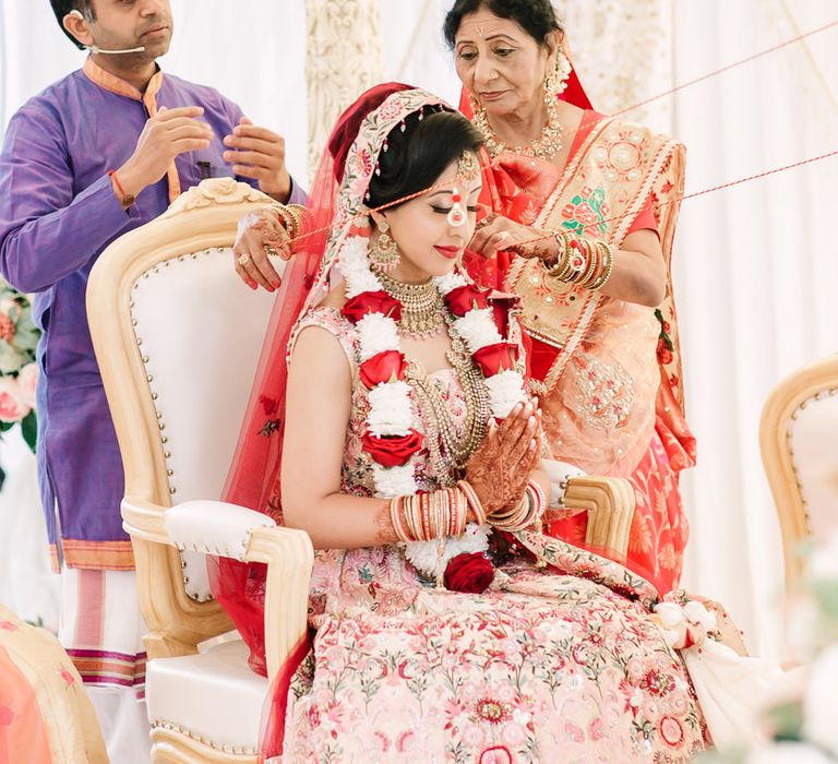 Hindu bride and groom being connected by string 