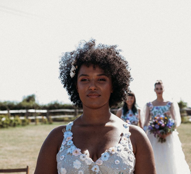 Bridesmaid walking down the aisle in embroidered dress 