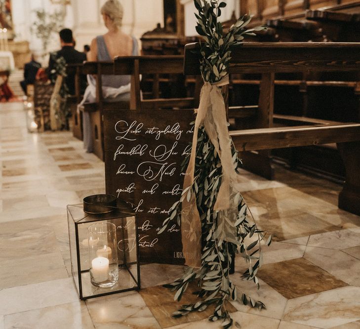 Olive bouquet details at the end of a church pew