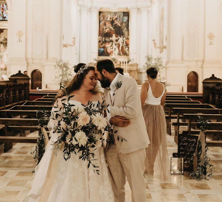 Just married at a church in Tuscany, holding an olive bouquet