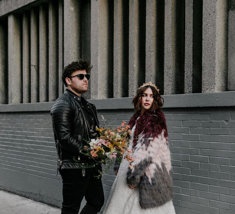 Bride & groom look back with groom wearing leather jacket and sunglasses 