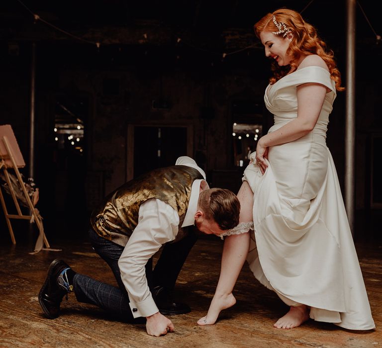 Groom removing his brides wedding garter 