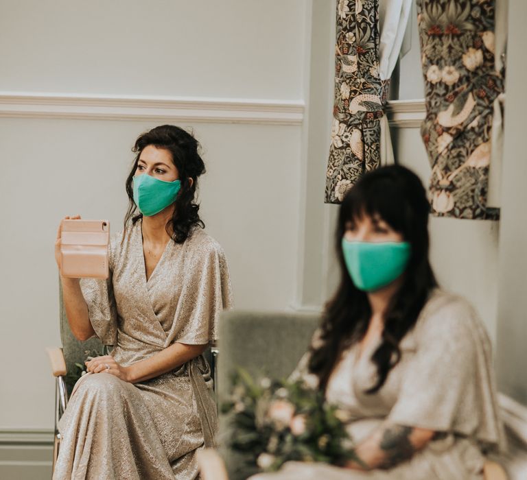 Bridesmaids sit with face masks