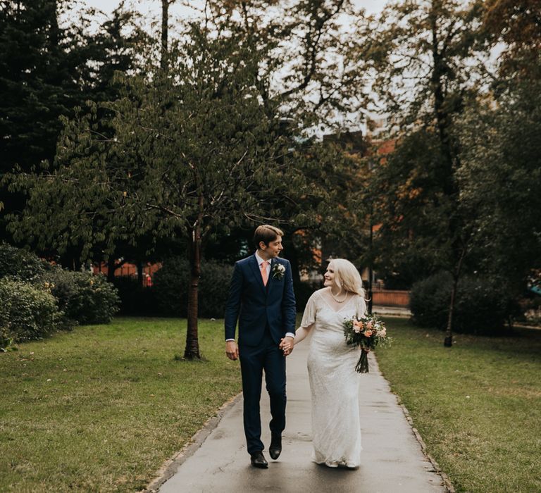 Bride & groom walk together on their wedding day 