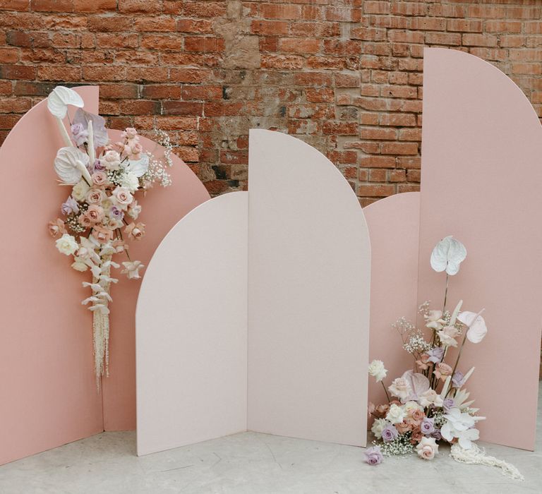 Pink geometric altar backdrop with tropical flower decor 