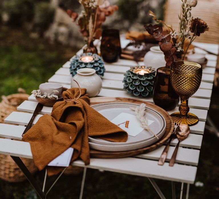 Outdoor table setting with white plates and wooden placemats