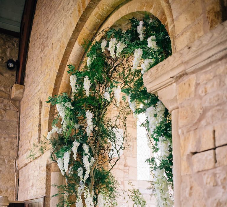 White and green foliage flower arch for church wedding