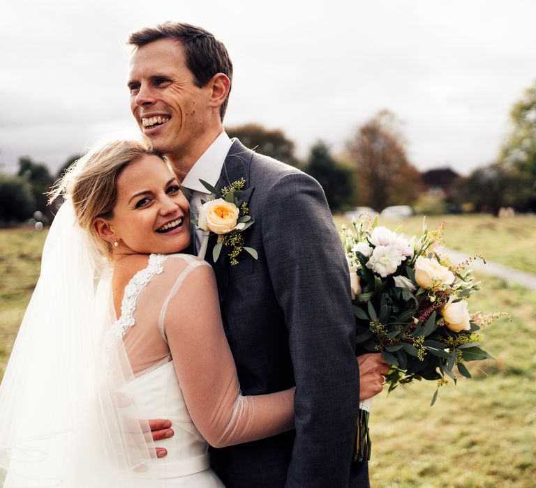 Bride & groom embrace outdoors on the morning of their wedding