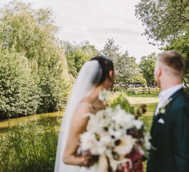 Bride & groom stand together in the countryside 