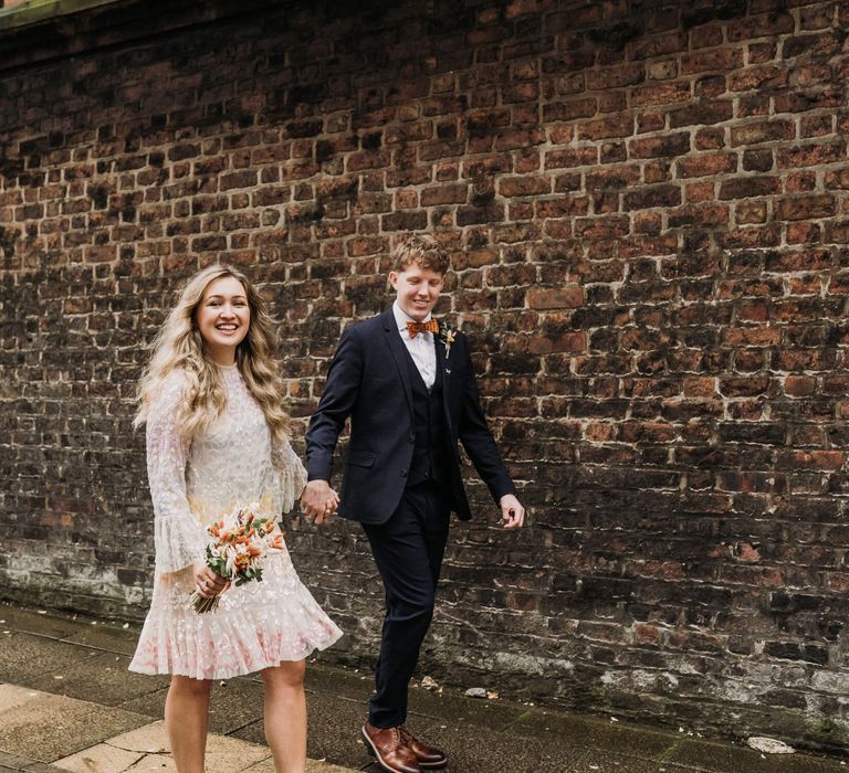 Bride and groom in Manchester, bride wears knee length long sleeve multi coloured pastel dress