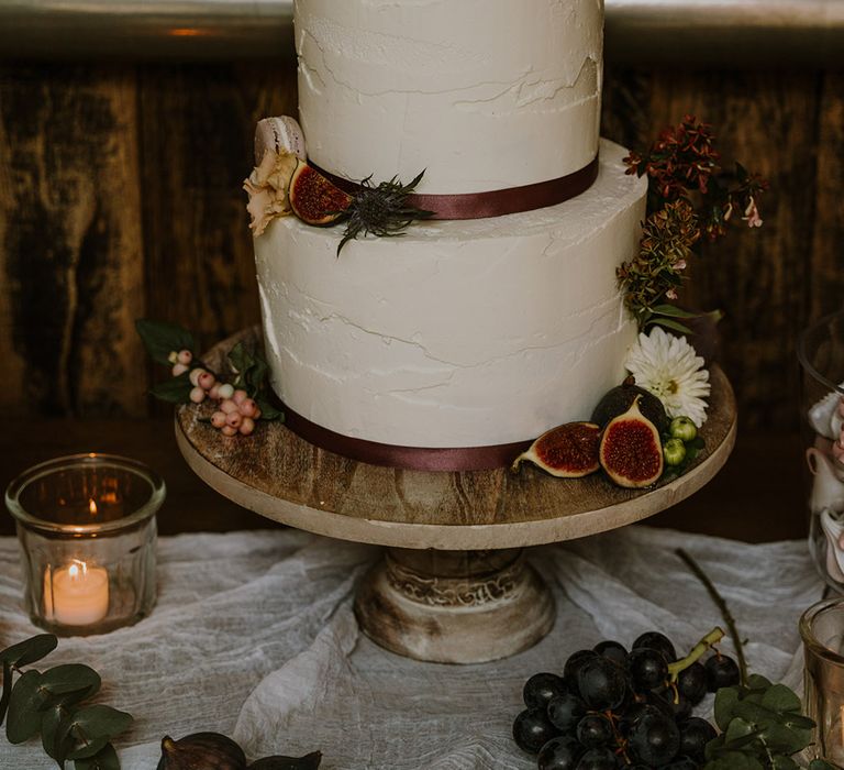 Three tier buttercream wedding cake on a wooden cake stand