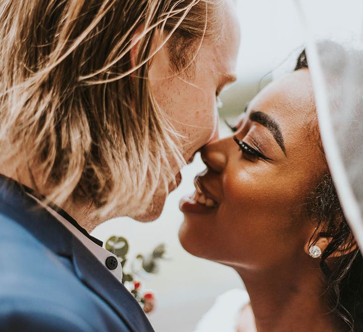 Intimate bride and groom portrait with the bride about to kiss her grooms cheek