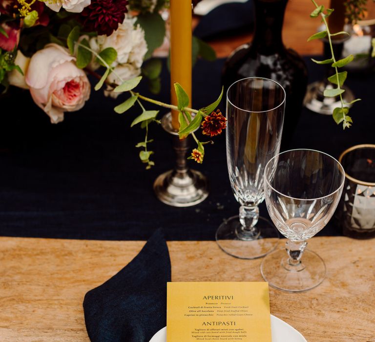 Yellow wedding menu with navy linen napkin and white tableware for stylish Tuscany elopement