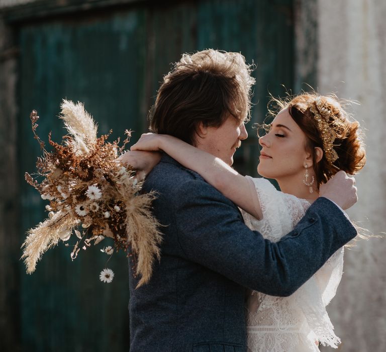 Bride & groom kiss outside blue door for elopement