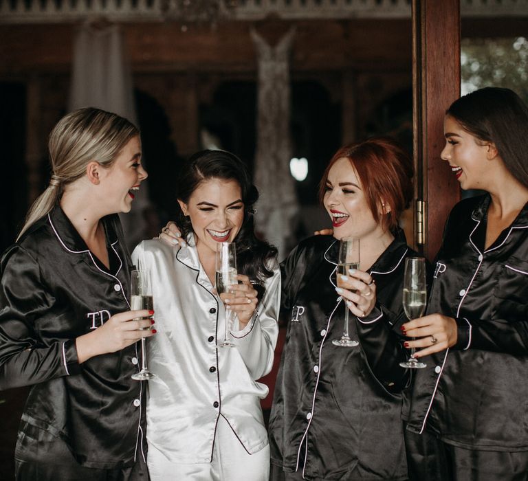 Bride and bridesmaid in matching silver and black satin pyjamas