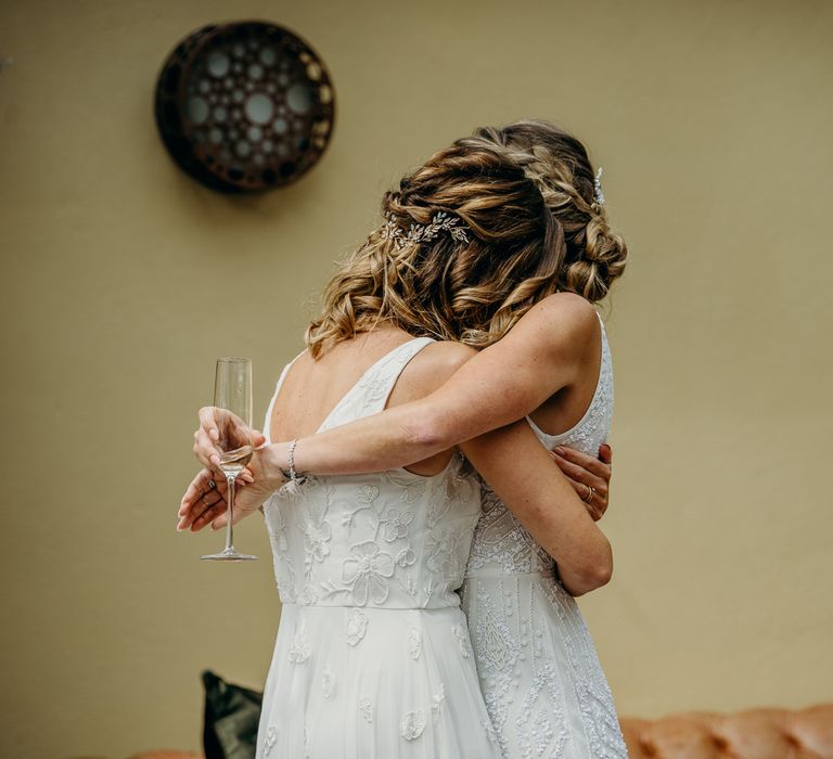 Brides embrace on their wedding day 