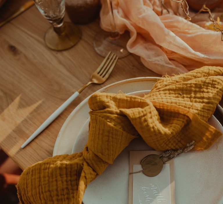 Mustard linen napkins on wedding place setting