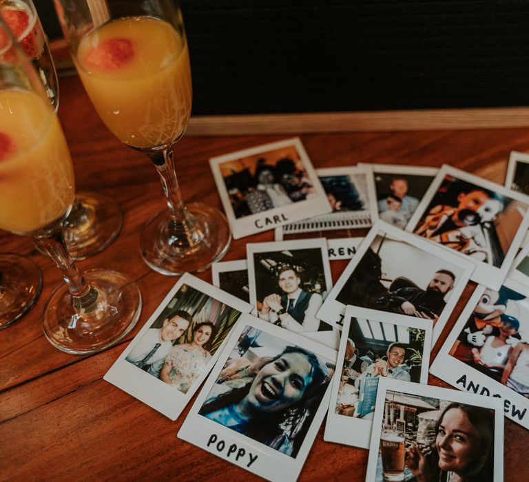 Polaroid pictures sit on table top for guest place name cards