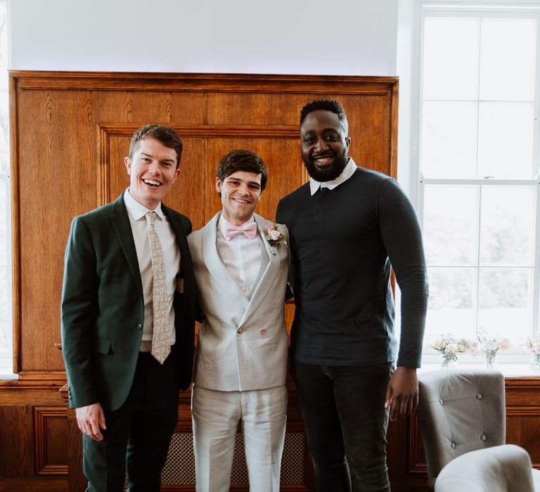 Groom stands with friends on the day of his wedding