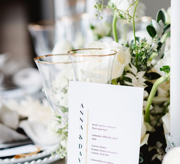 Close up of black and white wedding stationery with a vertical design. The card is white, writing black and there is gold leaf detailing.