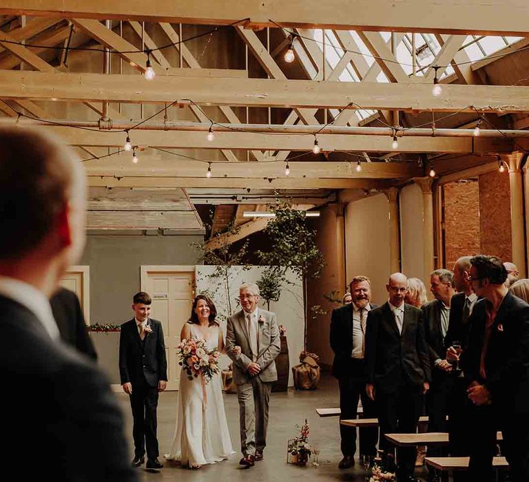 Bride walks down the aisle at industrial venue