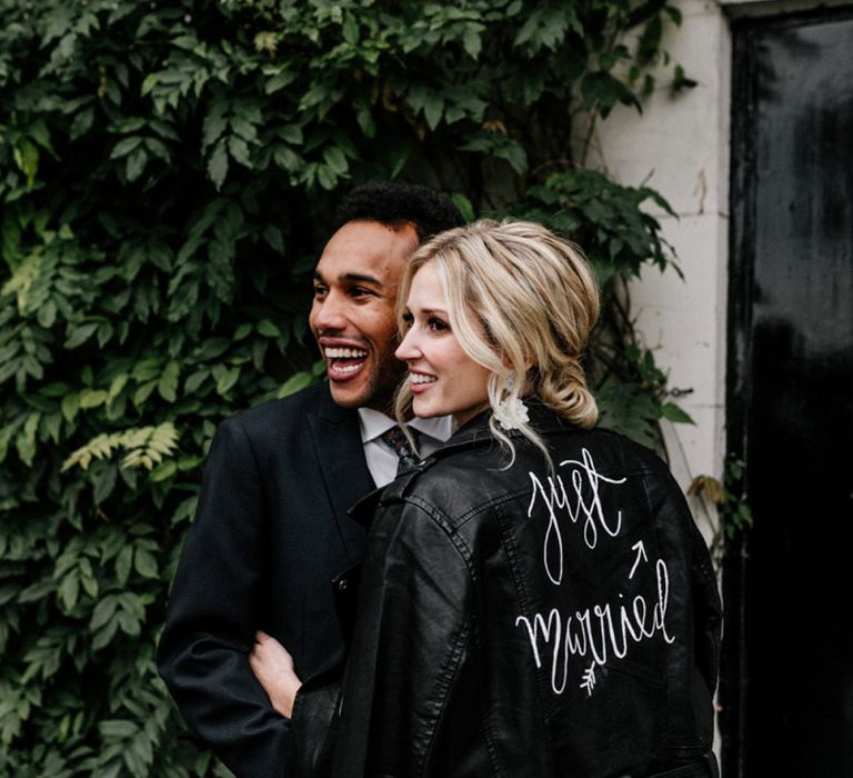 Stylish bride in a black leather jacket with white 'Just Married' inscription 