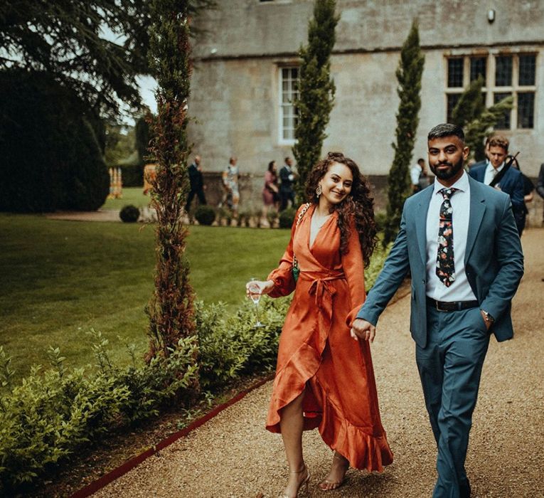 Wedding guests walk together through the grounds of Elmore Court