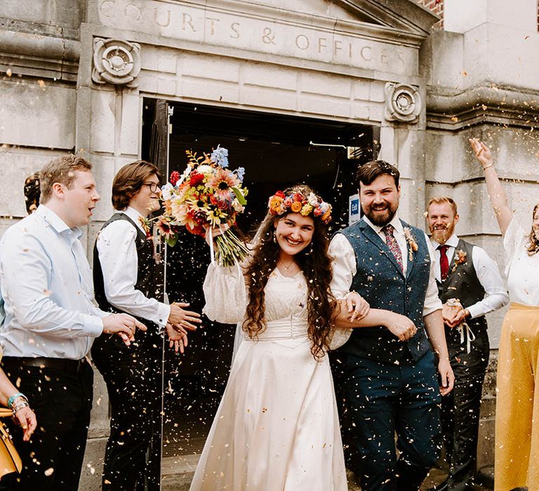 Bride & groom leave ceremony together as wedding party throw confetti around them