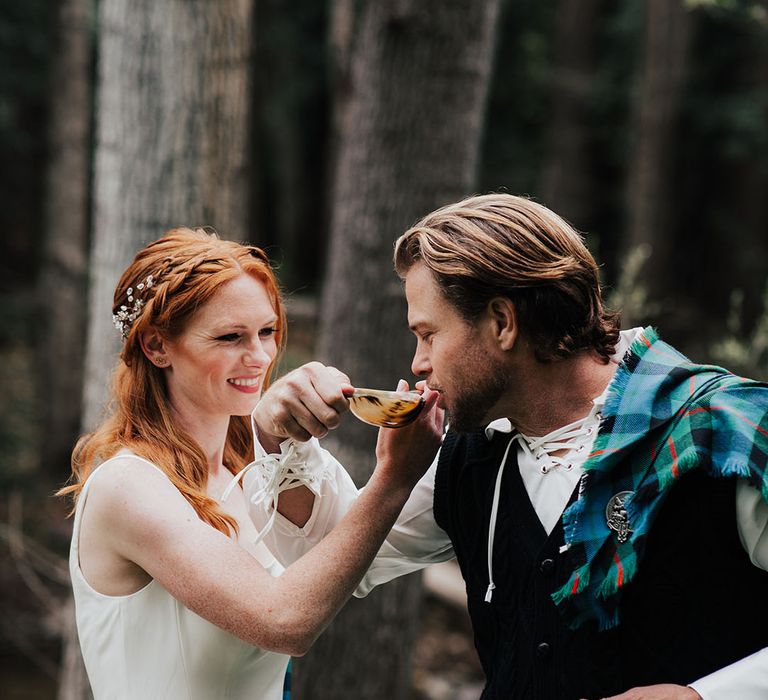 Scottish highland wedding with bride and groom drinking from the quaich cup