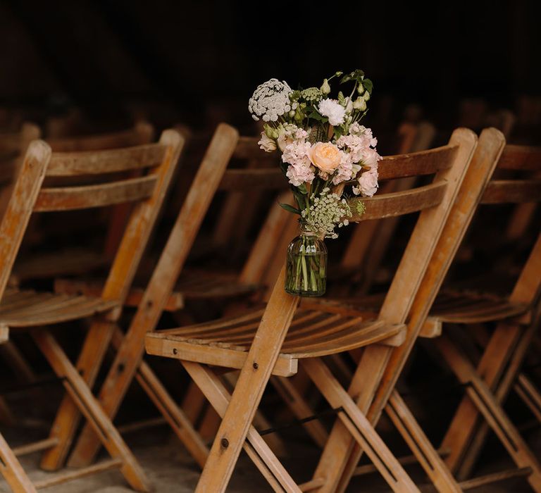 Wooden wedding chairs with flower decor for ceremony