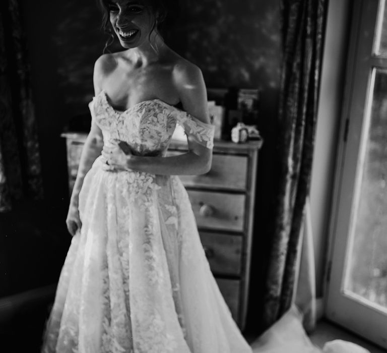 Bride smiles in her lace wedding dress