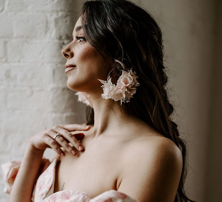 Bride in an off the shoulder pink print bridal separates with dried flower earrings and wrist corsage by Luna And Wild 