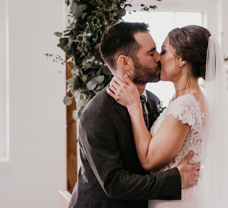 Bride & groom kiss after wedding ceremony as bride wears Lusan Mandongus Dress