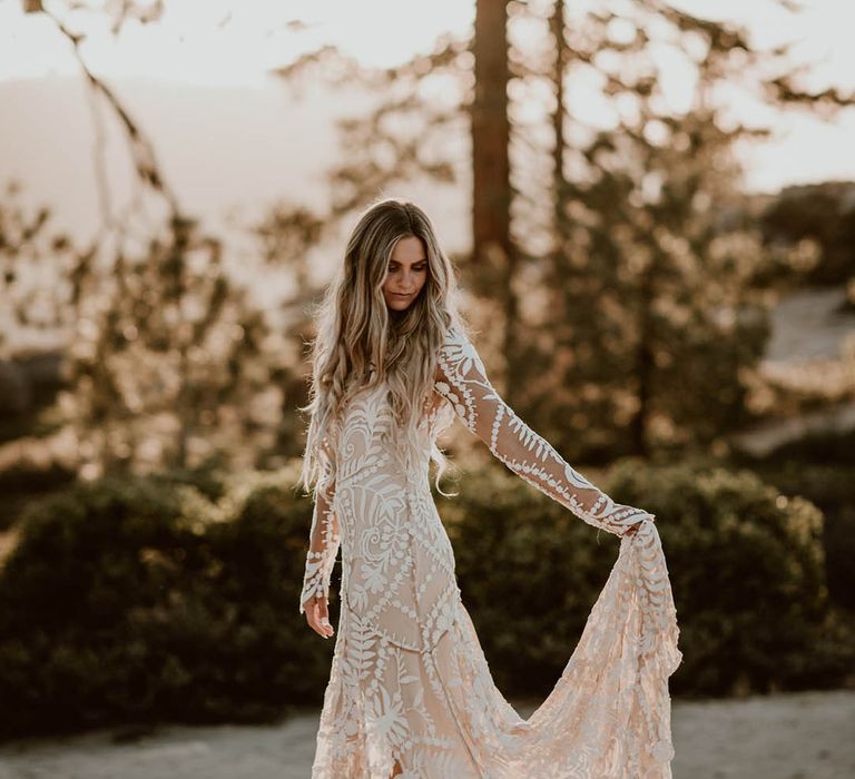 Bride holds the train of her dress on her wedding day