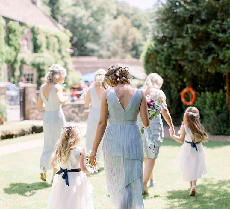 Bridesmaids walk with flower girls