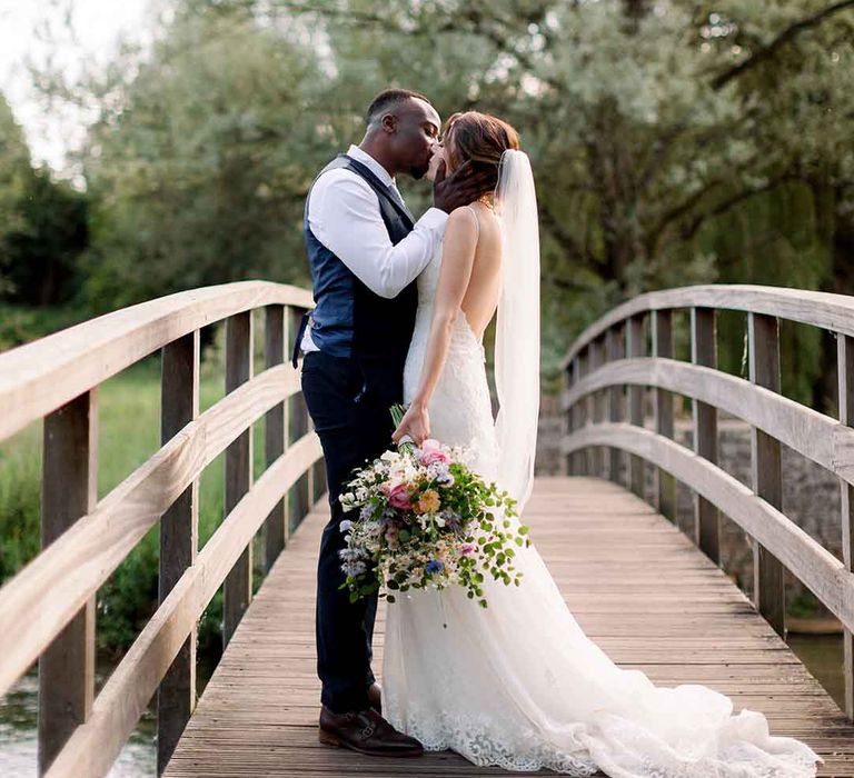 Bride & groom kiss outdoors in the Cotswolds on their wedding day