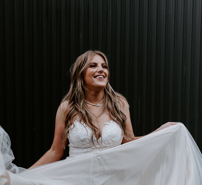 Bride with long hair in Vivienne Westwood diamanté and pearl necklace and v-neck wedding gown