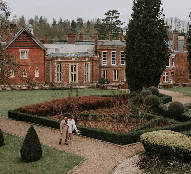 Bride and groom walking around the grounds of Leatherhead Registry Office, Wotton House