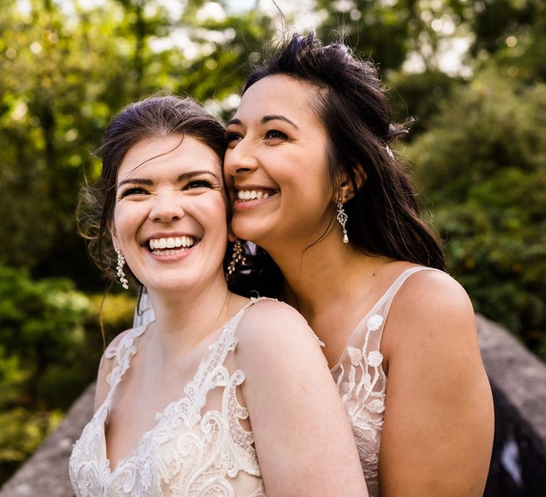 Smiling brides stand together on their wedding day at Foxtail Barns wedding venue