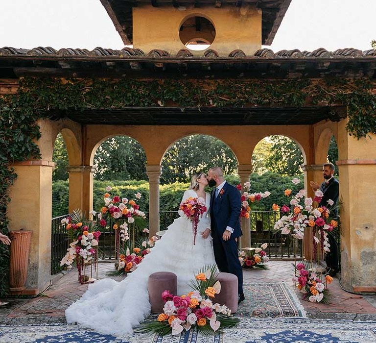 Bride & groom marry outdoors in Florence Italy surrounded by bright floral bouquets