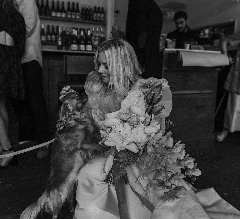 Black and white portrait of the bride with her King Charles Spaniel dog on her wedding day 