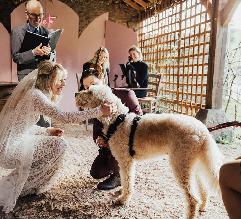 The couple give Dug the dog some loving during their wedding ceremony 